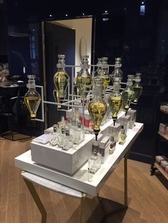 many bottles and glasses are on display in a room with wood flooring at the bottom