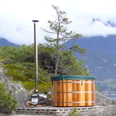 a wooden hot tub sitting on top of a rocky hillside