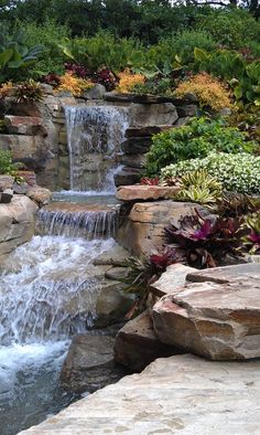 there is a waterfall in the middle of this garden