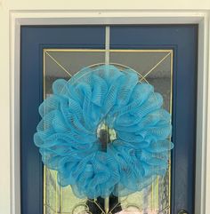 a blue wreath is hanging on the front door