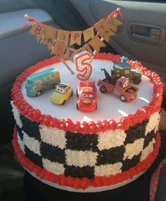 a birthday cake with cars on it in the car