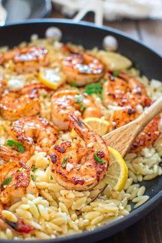 shrimp and rice with lemon wedges in a skillet