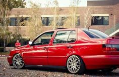 a red car parked in front of a brick building