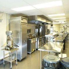 an industrial kitchen with stainless steel appliances and counters