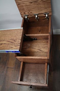 an open wooden drawer on top of a hard wood floor