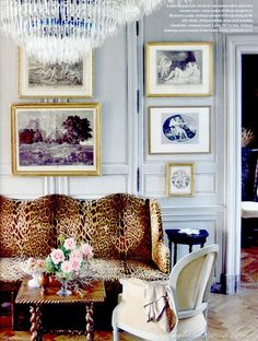 a living room filled with furniture and pictures on the wall above it's chandelier