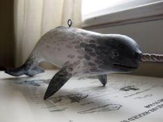 a toy dolphin is sitting on top of a piece of paper