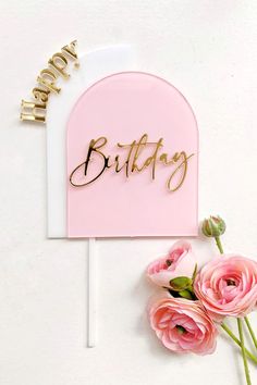 a pink and gold birthday cake topper with flowers