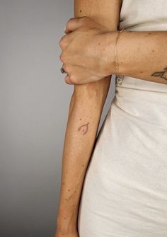 a woman's arm with a small tattoo on the left side of her arm