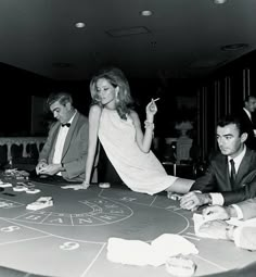 a group of people sitting around a table with cards and chips in front of them