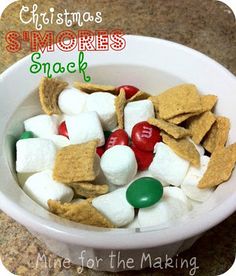 a white bowl filled with marshmallows, candy and s'mores