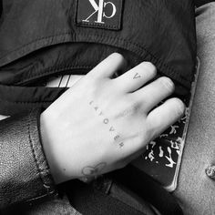 a person's hand with the word love tattooed on it