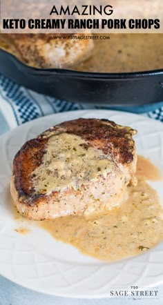 a white plate topped with meat covered in gravy next to a skillet