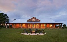 a large wooden house sitting on top of a lush green field