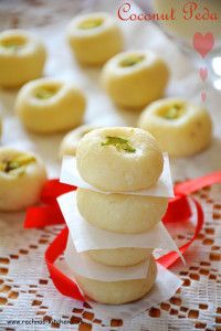 small desserts stacked on top of each other with red ribbon around the edges and decorated with green leaves