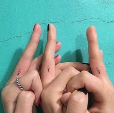 two hands making the peace sign with their fingers and one hand holding another's finger