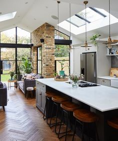 an open concept kitchen and living room with skylights