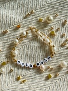 a bracelet that says goldrush on it with pearls and other beads around it