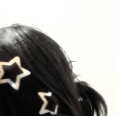 the back of a woman's head with star shaped hair clips