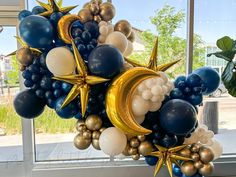 a bunch of balloons in the shape of stars and crescents on a window sill