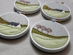 four handmade embroidered hoop earrings with houses and trees on the field in green tones