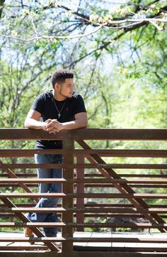 a man standing on top of a wooden bridge