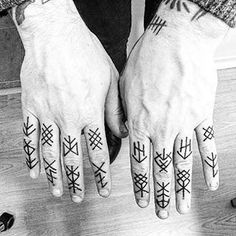 black and white photograph of two hands with tattoos on them