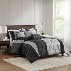 a bed with black and white comforters in a room