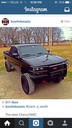 the truck is black and has some big tires on it's rims,