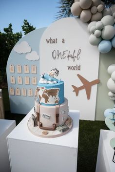 a blue and white cake sitting on top of a table in front of a sign