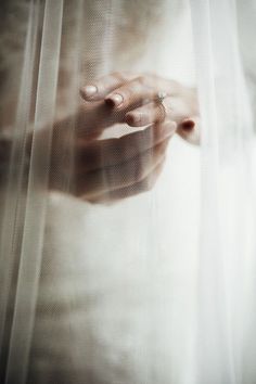 a person holding their hand out through the sheer curtain