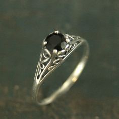 Filigree Engagement Ring Cinderella Onyx Ring Antique Style Ring Vintage Style Ring Scrollwork Solitaire 5mm Black Stone Ring Blazer Arts"If you keep on believing, the dream that you wish will come true"Cinderella sparks memories of glass slippers, fairy god mothers, and dancing at midnight. This is her ring...dainty, intricate and as stunning as can be! A detailed filigree setting securely holds a 5mm Facetted Onyx. It is surrounded by intricate vining filigree. The top of the sterling silver r Black Crystal Ring, Antique Style Rings, Black Stone Ring, Filigree Engagement Ring, Rutilated Quartz Ring, Tourmalinated Quartz, Handmade Engagement Rings, Vintage Style Rings, Hot Jewelry