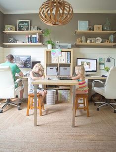 two children sitting at a desk with computers