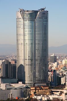 two tall skyscrapers in the middle of a city with mountains in the back ground