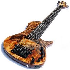 an electric bass guitar made out of wood and metal with black knobs on the neck