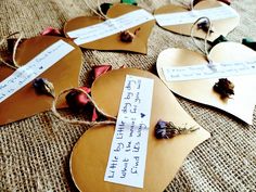 several pieces of heart shaped paper with writing on them and dried flowers in the middle