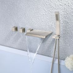 a faucet with water running from it and flowers in the bathtub next to it