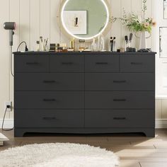 a dresser with a mirror and various items on it in a room that has white walls