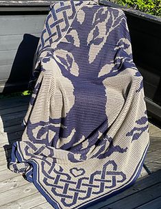 a blue and white blanket sitting on top of a wooden deck