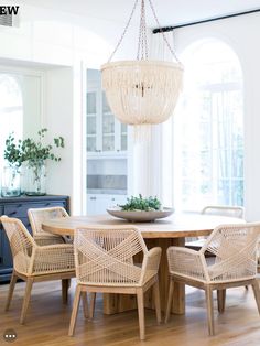 a dining room table with chairs and a chandelier hanging from it's ceiling