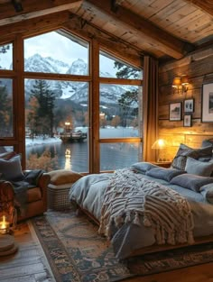 a bedroom with a large bed and lots of pillows on the floor next to a window