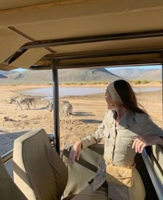 a woman sitting in the back of a safari vehicle