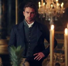 a man standing in front of a table with candles