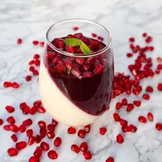 a glass filled with pudding and garnished with pomegranates