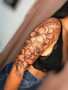 a woman's arm with flowers on it and a black lace around the arm