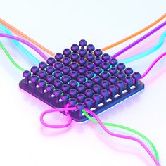 a purple computer keyboard with lots of colorful beads on it's back and sides