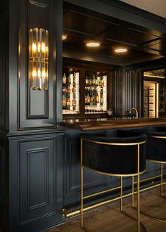 an elegant bar with black velvet stools and gold accents