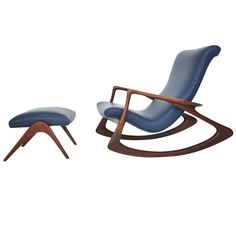 a blue chair and ottoman sitting next to each other on a white surface with one foot in the air