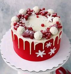 a red and white frosted cake with berries on top