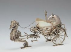 a silver carriage with a sea horse pulling it